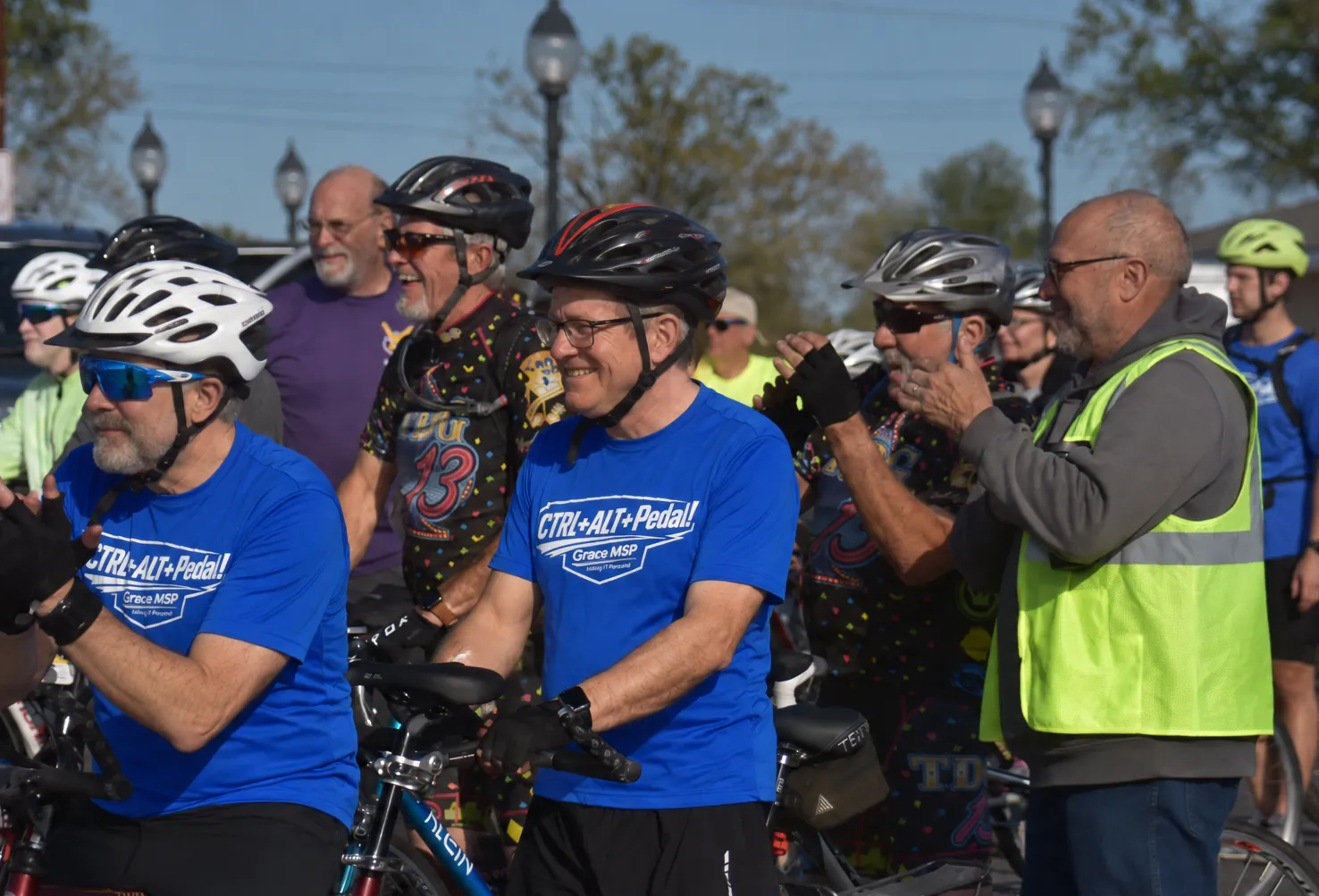 GraceMSP riders in blue Ctrl+Alt+Pedal! shirts and helmets, smiling at the start line of Amy’s Ride.